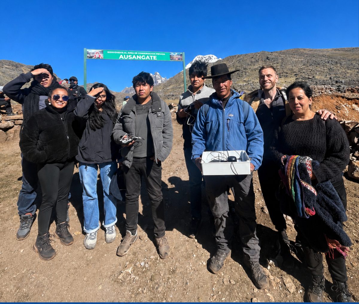 The field team at the entrance sign to the Ausangate private conservation area, in the Cusco region.